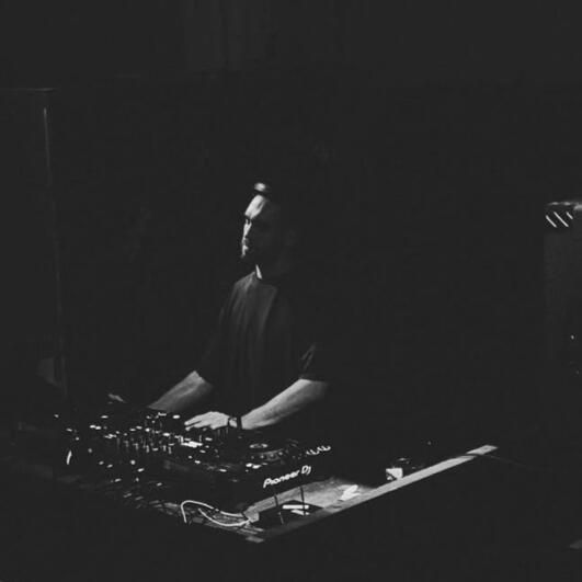 JF.HECTOR at the decks in a dark club.